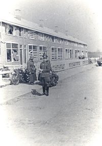 18. Duitse militairen bij woonhuizen tijdens de tweede wereldoorlog.