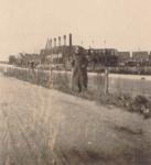 50. Een Duitse militair poseert bij de uitgebrande school aan de Admiraal de Ruyterweg in mei 1940 in Dordrecht thumbnail