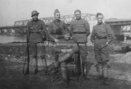 Soldaat Bour met zijn kameraden van het luchtverdedigingspunt Zwijndrecht. Soldaat Bour staat uiterst links met helm op en karabijn in de hand. Hij draagt een gasmaskertas. Op de achtergrond de bruggen over de Oude Maas.